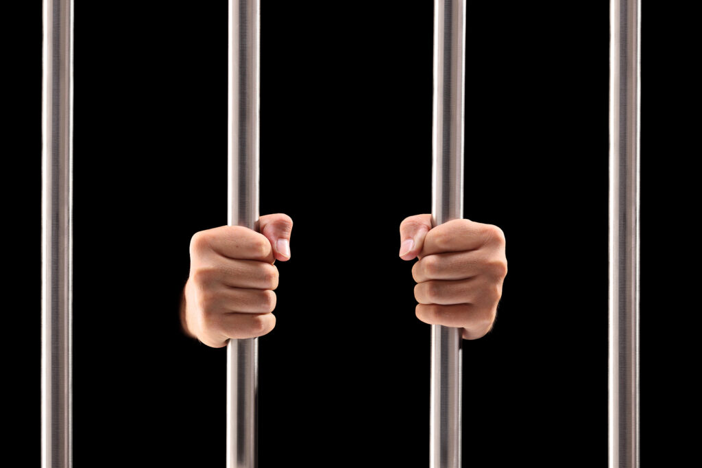 holding prison jail cell bars black background